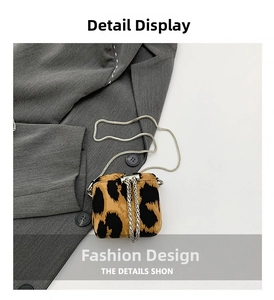 Detail of leopard print crossbody bag with silver metal chain and sleek cylindrical clasp