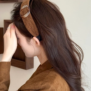 Brown velvet padded headband with round buckle accessory on a fashion model