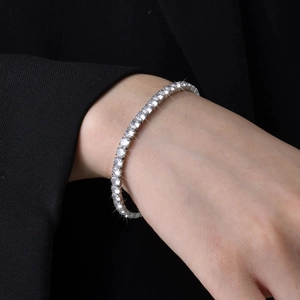 Detail of silver tennis bracelet with cubic zirconia stones on female model wrist