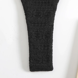Macro shot showing the intricate floral lace pattern and mesh texture of the black bikini cover-up