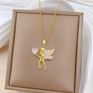 Macro detail of gold Cupid pendant with heart-shaped gemstone and crystal wings