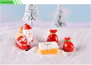 Macro view of miniature Christmas figurines including Santa Claus and a snowy chimney