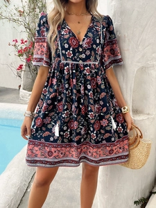 Detail of V-neckline with tassel ties and bohemian floral print on summer dress