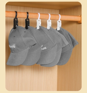 Rotating closet hook clips holding baseball caps on a wooden bar for tidy storage