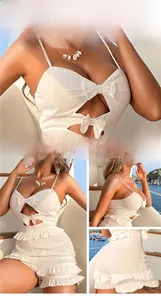 Close-up of white pinstripe summer set with cut-out details and decorative bows