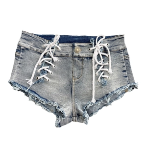 Dettaglio di pantaloncini in denim azzurro con lacci laterali e orli sfrangiati