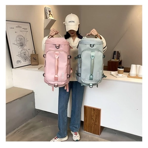 Detailed view of pink and blue waterproof nylon travel backpacks with top handles