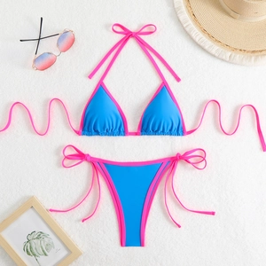 Close-up of royal blue bikini with pink strings on a white faux fur background