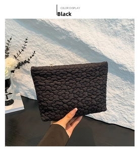 Detail of black quilted floral texture on a minimalist polyester clutch bag for women