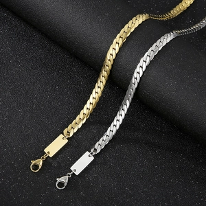 Detailed view of gold and silver stainless steel curb chain bracelets with engravable plates