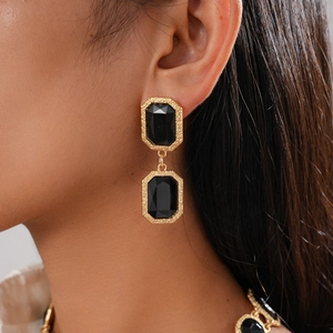 Gros plan sur les boucles d'oreilles vintage en cristal noir et bordure dorée