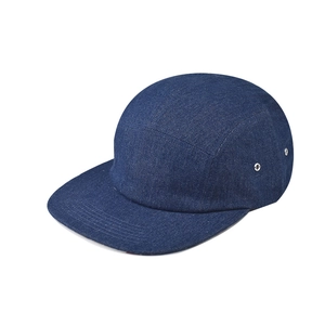 Detailed macro view of dark blue denim 5-panel camp cap with metal side eyelets