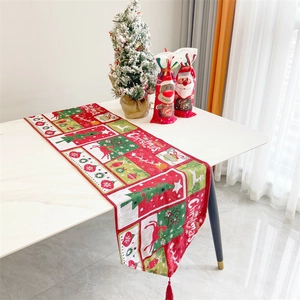 Close-up of a festive cotton-linen Christmas table runner with red tassels and patterns