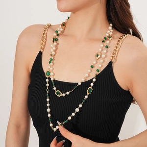 Vintage multi-layer pearl necklace with green gemstone on a model in golden finish