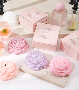Detailed view of peony flower shaped scented candles in pink, purple and white gift boxes