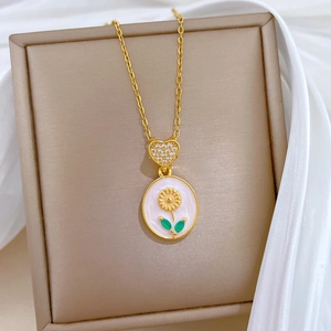 Luxurious gold necklace with enamel sunflower pendant and diamond heart on silk background