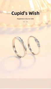 Detail of Cupid Feather silver couple rings featuring heart wing design and single diamond inlay