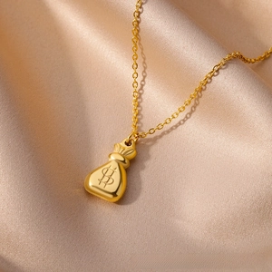 Close-up of golden money bag pendant with currency symbol on champagne satin background