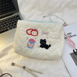 Detailed heart quilted makeup bag with colorful embroidery and light blue zipper closure