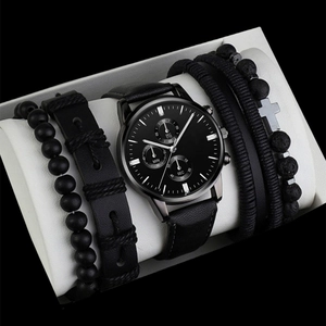 Detail of men's minimalist black watch set with leather straps and four fashion bracelets