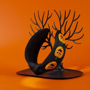Detail of handcrafted orange beadwork pumpkins on a black knotted Halloween headband