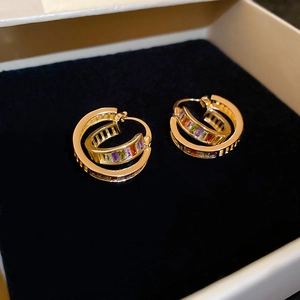 Close-up of 18K gold plated hoop earrings with rainbow baguette zircons on black velvet