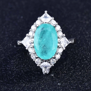 Macro top view of Paraiba-style oval blue gemstone ring with micro-pave white zircon halo