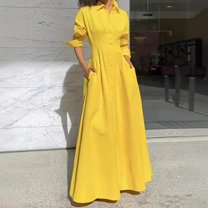 Detail of elegant yellow button-down shirt dress featuring pleated waist and side pockets