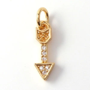 Macro shot of a golden arrow charm featuring sparkling pave-set cubic zirconia crystals