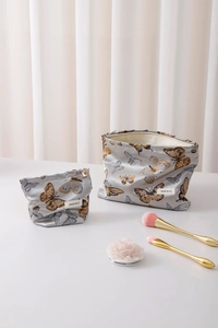 Detail of silver butterfly print cosmetic bag set with zipper and brand label
