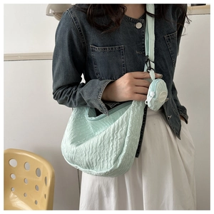 Detail of mint green ruched cloud bag with matching mini round coin purse accessory