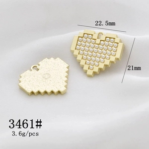 Macro shot of gold pixel heart charms with pearls and dimensions 22.5mm by 21mm