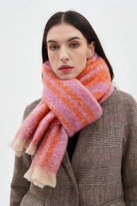 Detail of pink and orange striped bouclé scarf with soft fringe texture on model