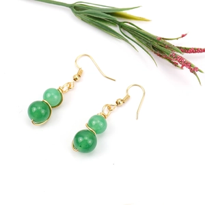 Detail of green crystal beads earrings with gold wire wrapping and gold ear hooks