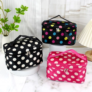 Three rectangular polka dot makeup bags with handles and zippers in stylish setup