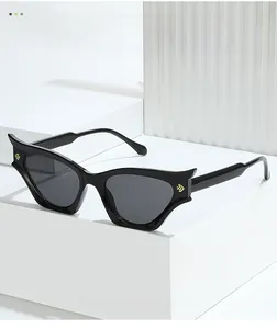 Detailed shot of black cat-eye sunglasses with golden temple accents on a stone pedestal