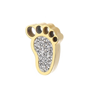 Detail of a golden paw pendant with clear faceted zircons on a white background