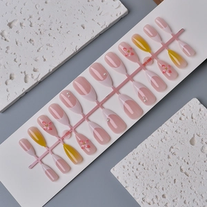 Detail of 24pcs almond press-on nails with 3D floral art and pearl accents