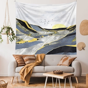 Detail of wall tapestry featuring abstract golden peaks and sunset over blue mountains