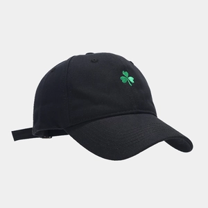 Détail de la broderie trèfle vert et de la texture coton sur casquette noire de baseball