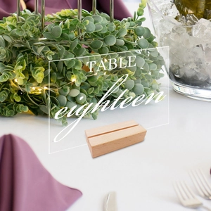 Clear acrylic table number eighteen with wooden base for wedding reception decor
