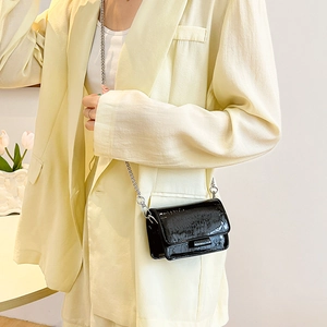 Chic black crocodile pattern mini crossbody bag with metal chain strap on female model