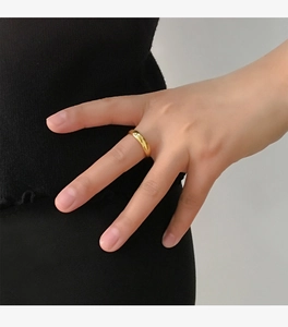 Close-up of a 4mm gold polished stainless steel ring worn on a person's finger