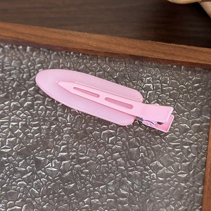Dettaglio molletta per capelli ovale rosa opaco con molla in metallo su vassoio