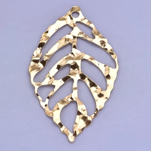 Macro detail of a 304 stainless steel leaf pendant with a gold hammer textured finish