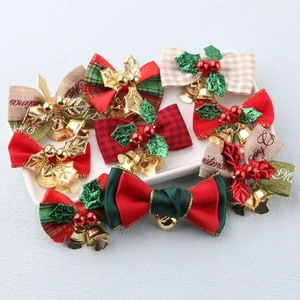 Flat lay of Christmas bow tie ornaments with bells in festive red, green, and gold colors