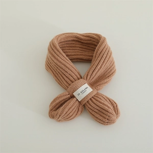 Detail of camel chunky rib-knit winter scarf with branded woven label on minimalist background
