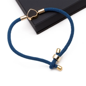 Detailed macro view of dark blue woven bracelet with a gold-edged black heart charm