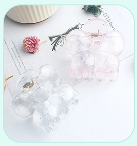 Detail of flower hair clips in transparent and pink resin with sturdy metal springs