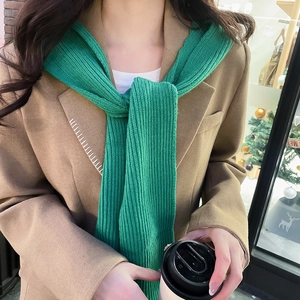 Detailed vertical rib knit texture of a warm emerald green hooded scarf for winter wear